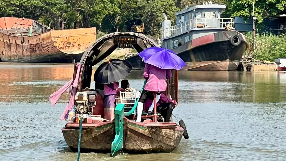 Menschen auf dem Pa Sak River schützen sich mit Sonnenschirmen vor der Sonneneinstrahlung und der extremen Hitze in Thailand. - Bild: Carola Frentzen/dpa