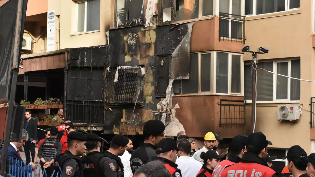 Einsatzkräfte stehen nach einem Brandausbruch vor einem teilweise verbrannten Gebäude. - Bild: Safar Rajabov/XinHua/dpa