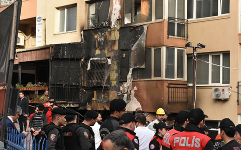 Einsatzkräfte stehen nach einem Brandausbruch vor einem teilweise verbrannten Gebäude. - Foto: Safar Rajabov/XinHua/dpa