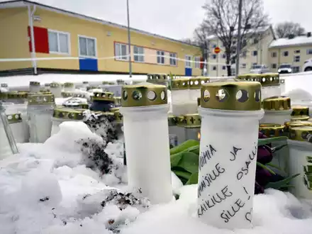 Kerzen und Blumen sind vor der in der Viertola-Schule im finnischen Vantaa aufgestellt. - Foto: Markku Ulander/Lehtikuva/dpa