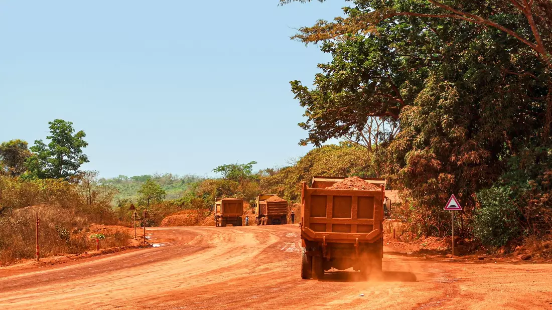 Lastwagen transportieren Bauxit entlang einer Bergbau-Transportstraße. Laut einer Studie werden mehr als ein Drittel der Menschenaffenpopulation in Afrika durch Bergbau gefährdet. - Bild: Claude Frenette/iDiv/dpa