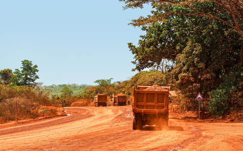 Lastwagen transportieren Bauxit entlang einer Bergbau-Transportstraße. Laut einer Studie werden mehr als ein Drittel der Menschenaffenpopulation in Afrika durch Bergbau gefährdet. - Foto: Claude Frenette/iDiv/dpa