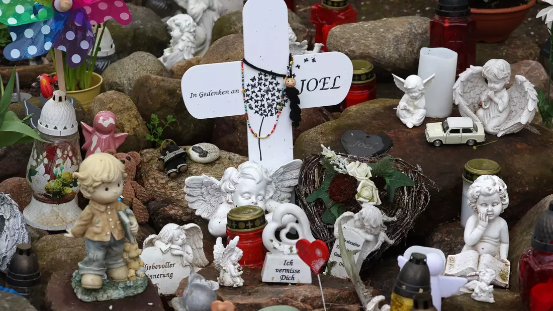 Kreuze, Figuren, Kerzen und Blumen stehen an der Stelle, wo der sechsjährige getötete Joel gefunden wurde. Der Prozess wegen Totschlags geht weiter. - Bild: Bernd Wüstneck/dpa