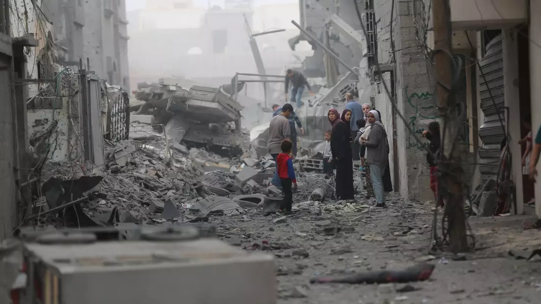 Menschen versammeln sich auf den Trümmern eines zerstörten Gebäudes nach einem Luftangriff im Flüchtlingslager Maghazi im Zentrum des Gazastreifens. - Bild: Uncredited/XinHua/dpa