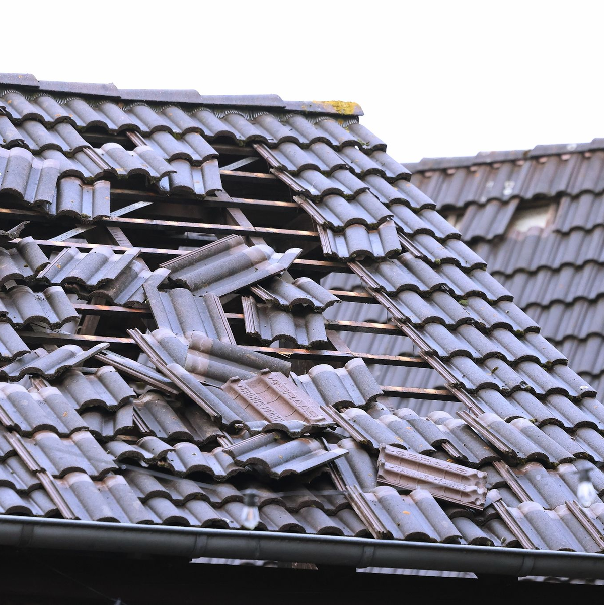 Ein Schild liegt nach einem Unwetter in Korschenbroich auf einer Straße. - Foto: David Young/dpa