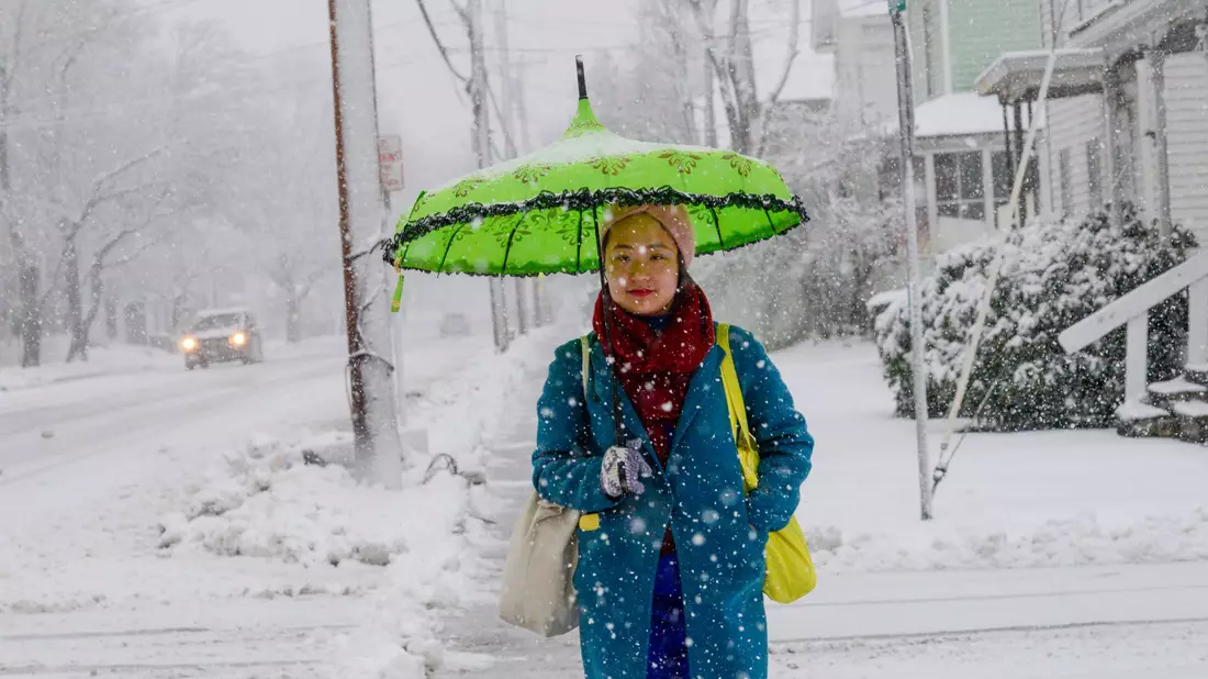 Eine Frau schützt sich in Bellows Falls in Vermont mit einem Schirm vor den Schneeflocken. - Bild: Kristopher Radder/The Brattleboro Reformer/AP/dpa