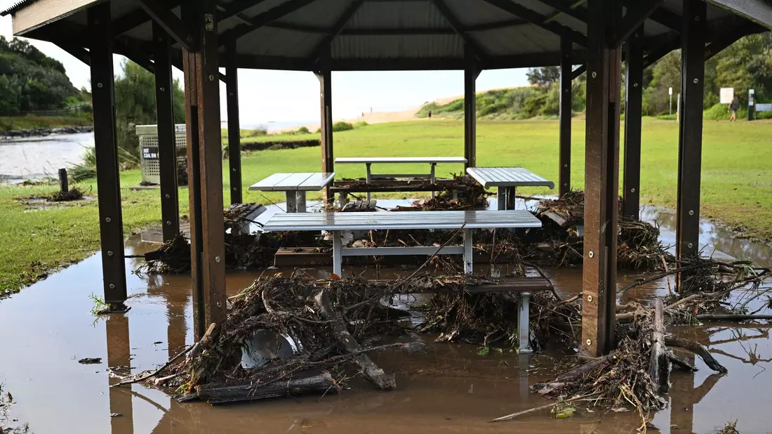 Sturmtrümmer liegen am Strand von Stanwell Park in der Illawarra-Region um Picknicktische herum. - Bild: Dean Lewins/AAP/dpa