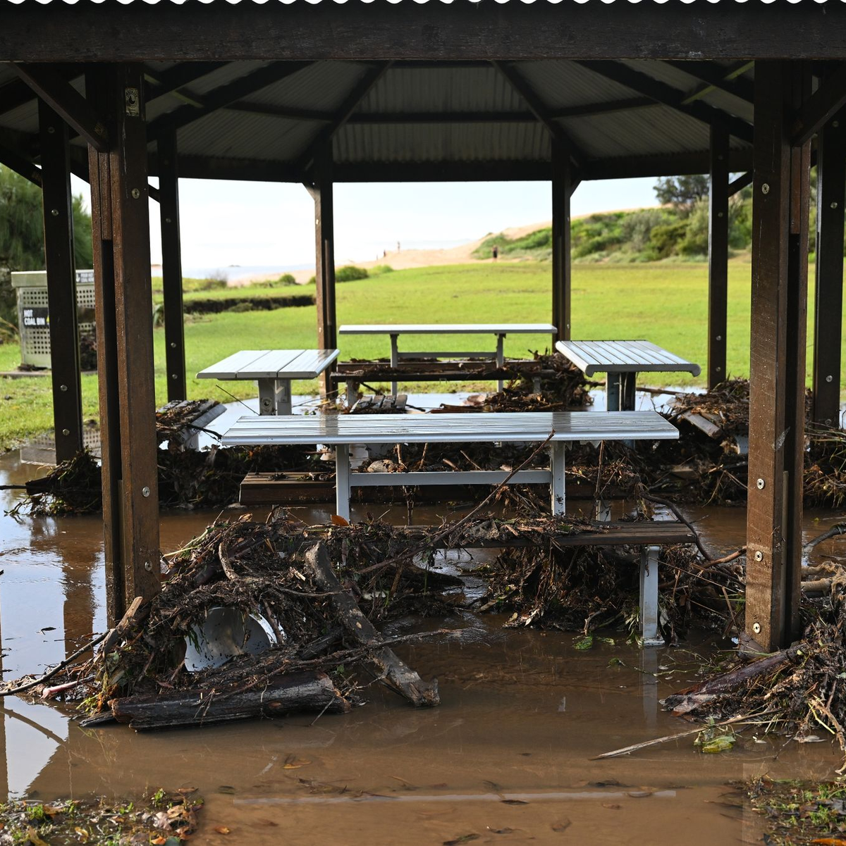Sturmtrümmer liegen am Strand von Stanwell Park in der Illawarra-Region um Picknicktische herum. - Foto: Dean Lewins/AAP/dpa