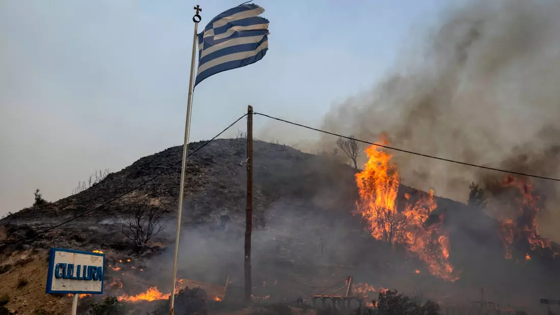 Flammen lodern im vergangenen Jahr auf einem Hügel auf Rhodos. - Bild: Petros Giannakouris/AP/dpa