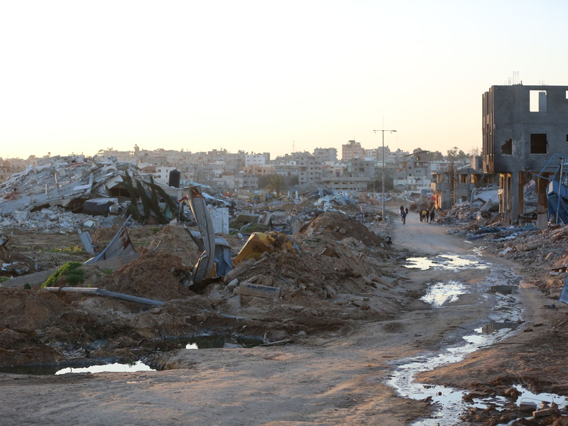 Menschen gehen an Trümmern und Ruinen auf einer Straße im Flüchtlingslager Al-Maghazi im Zentrum des Gazastreifens vorbei. - Foto: -/XinHua/dpa