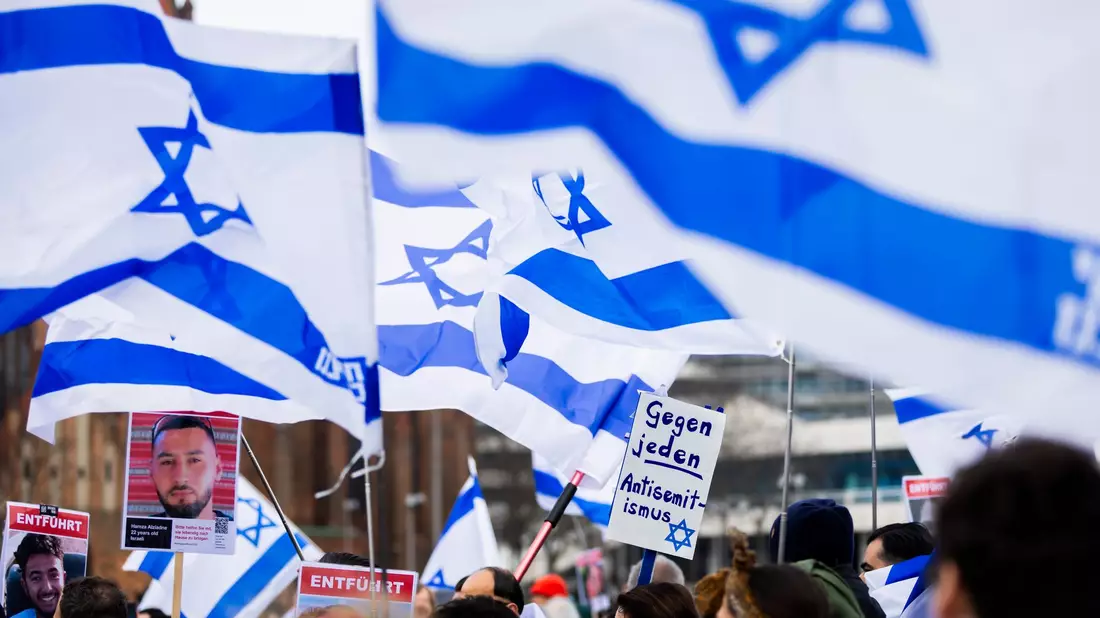 Menschen demonstrieren in Berlin mit Israelischen Fahnen gegen Antisemitismus und für Solidarität mit Israel. - Bild: Christoph Soeder/dpa