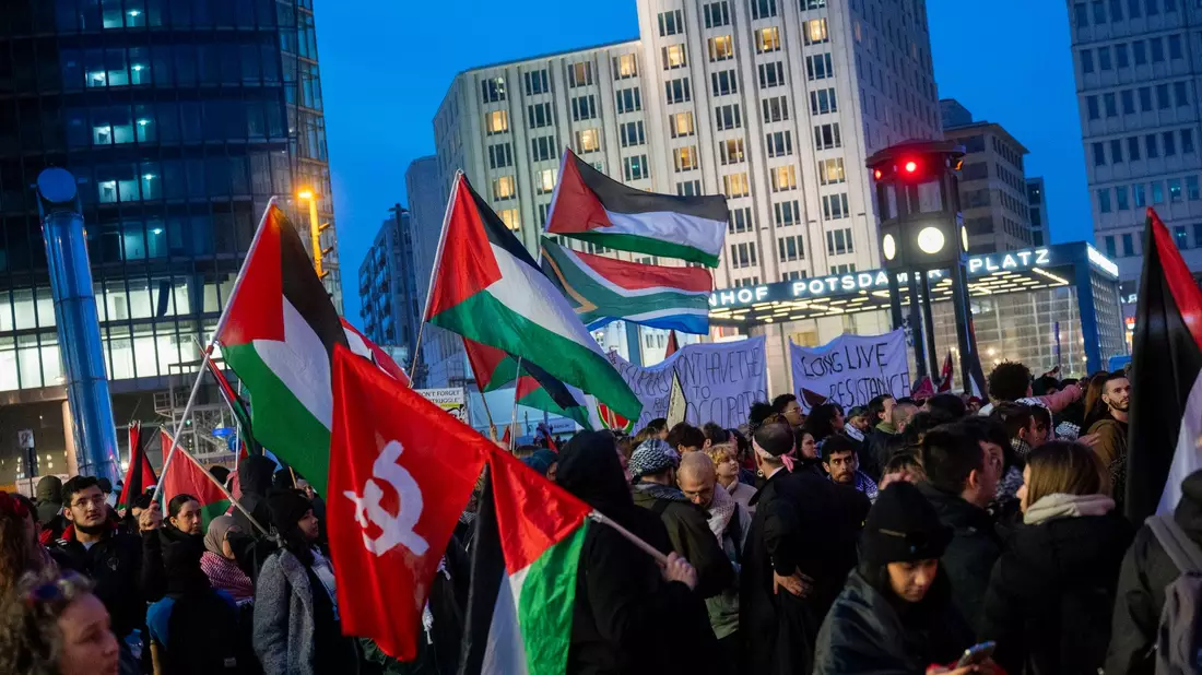 Teilnehmer einer pro-Palästina Demonstration stehen auf dem Potsdamer Platz in Berlin. - Bild: Christophe Gateau/dpa