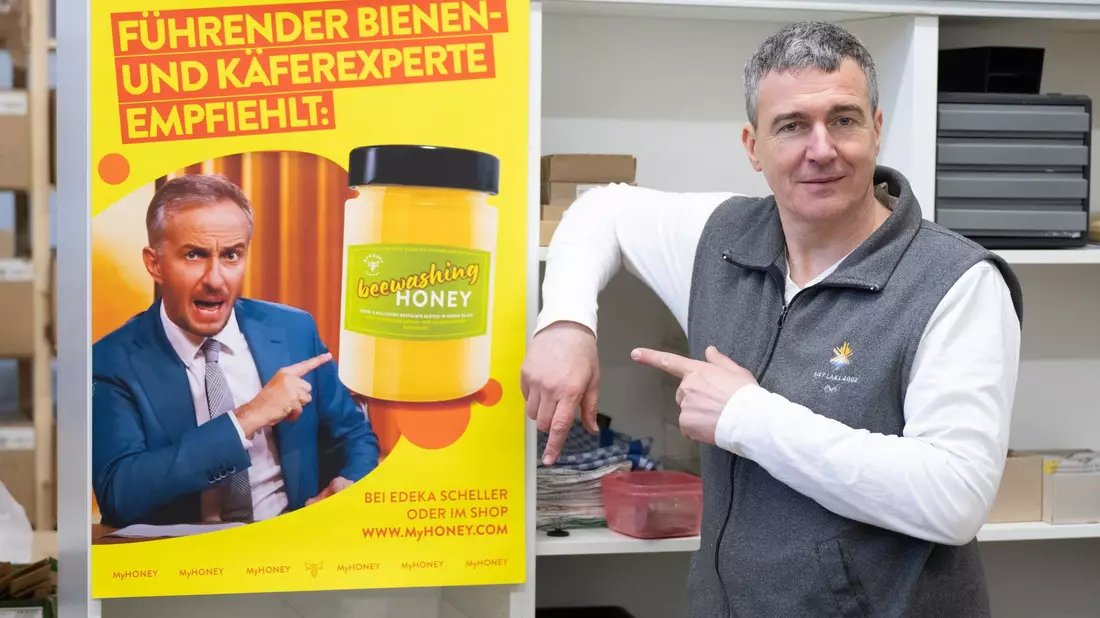 Imker Rico Heinzig neben einem Plakat mit dem Foto des Moderators Jan Böhmermann. - Bild: Sebastian Kahnert/dpa