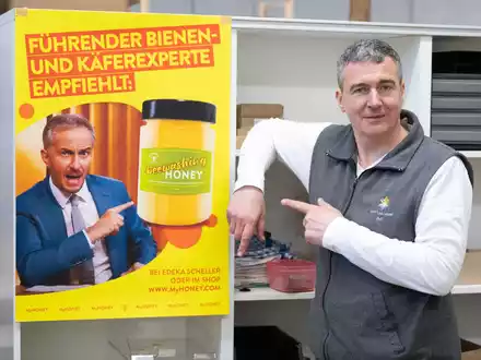 Imker Rico Heinzig neben einem Plakat mit dem Foto des Moderators Jan Böhmermann. - Foto: Sebastian Kahnert/dpa