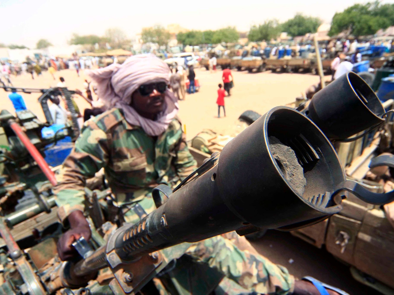 Ein Milizionär mit militärischer Ausrüstung, die angeblich während eines Gefechts im umkämpften Gebiet in Süd-Darfur erbeutet wurde. - Foto: Marwan Ali/EPA/dpa