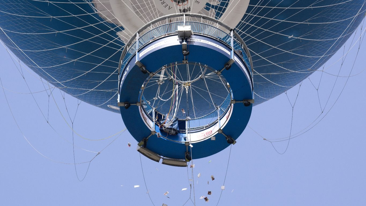 Israelische Angehörige von Hamas-Geiseln werfen Zettel mit Fotos von Geiseln aus einem Heißluftballon in Berlin-Mitte. - Foto: Bernd von Jutrczenka/dpa