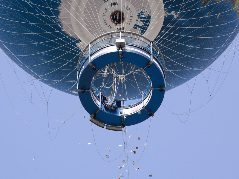 Israelische Angehörige von Hamas-Geiseln werfen Zettel mit Fotos der Verschleppten aus einem Heißluftballon in Berlin-Mitte. - Foto: Bernd von Jutrczenka/dpa