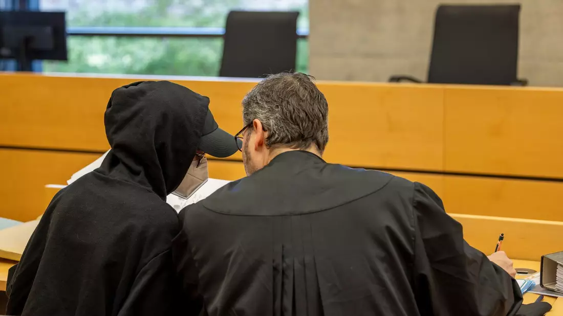 Eine der beiden Angeklagten (l) unterhält sich mit ihrem Rechtsanwalt im Sitzungssaal im Landgericht. - Bild: Heiko Becker/dpa