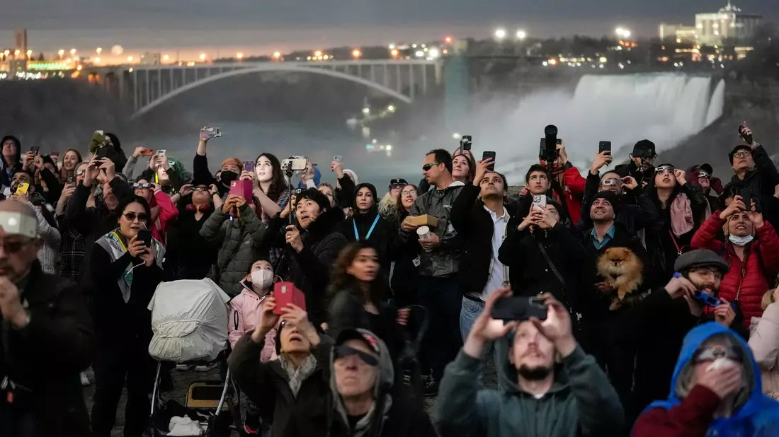 Auch vor den Niagarafällen in Ontario treffen sich zahlreiche Menschen, um die totale Sonnenfinsternis zu beobachten. - Bild: Matt Rourke/AP/dpa
