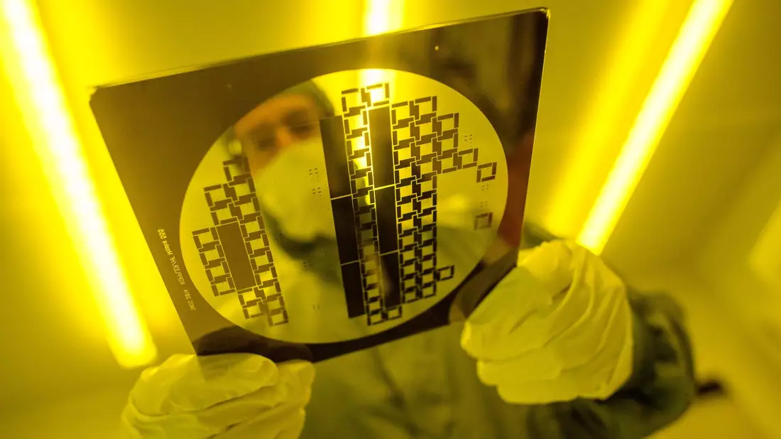 Ein Mann trägt in einem Reinraum eine sogenannte «Maske» zur Herstellung von Halbleiterstrukturen durch den Reinraum. Deutschland hat laut Deloitte gute Voraussetzungen für den Aufbau einer eigenen Chip-Produktion. - Bild: Klaus-Dietmar Gabbert/dpa