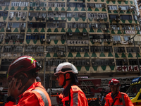 Im Hintergrund ist das ausgebrannte Hochhaus in Hongkong zu sehen - bei der Feuerwehr waren zahlreiche Hilferufe eingegangen. - Foto: Louise Delmotte/AP