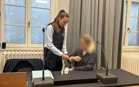 Eine Justizmitarbeiterin nimmt der Angeklagten beim Prozessauftakt vor dem Landgericht Ravensburg die Handschellen ab. - Foto: Aleksandra Bakmaz/dpa