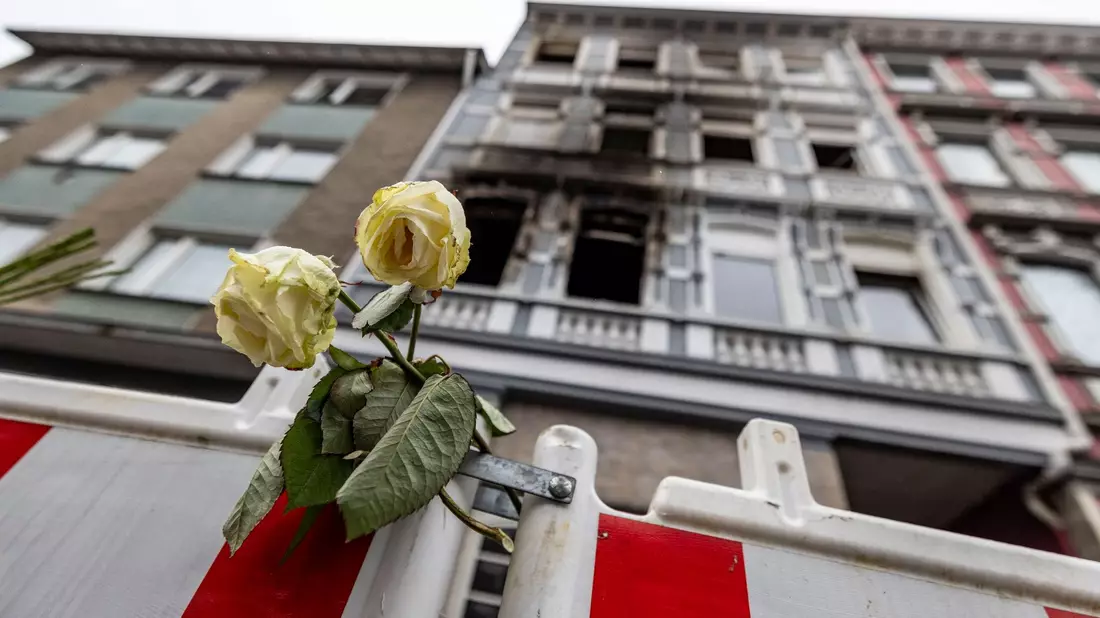 Eine weiße Rose an einer Absperrbake vor dem Brandort in Solingen am 27. März. - Bild: Christoph Reichwein/dpa