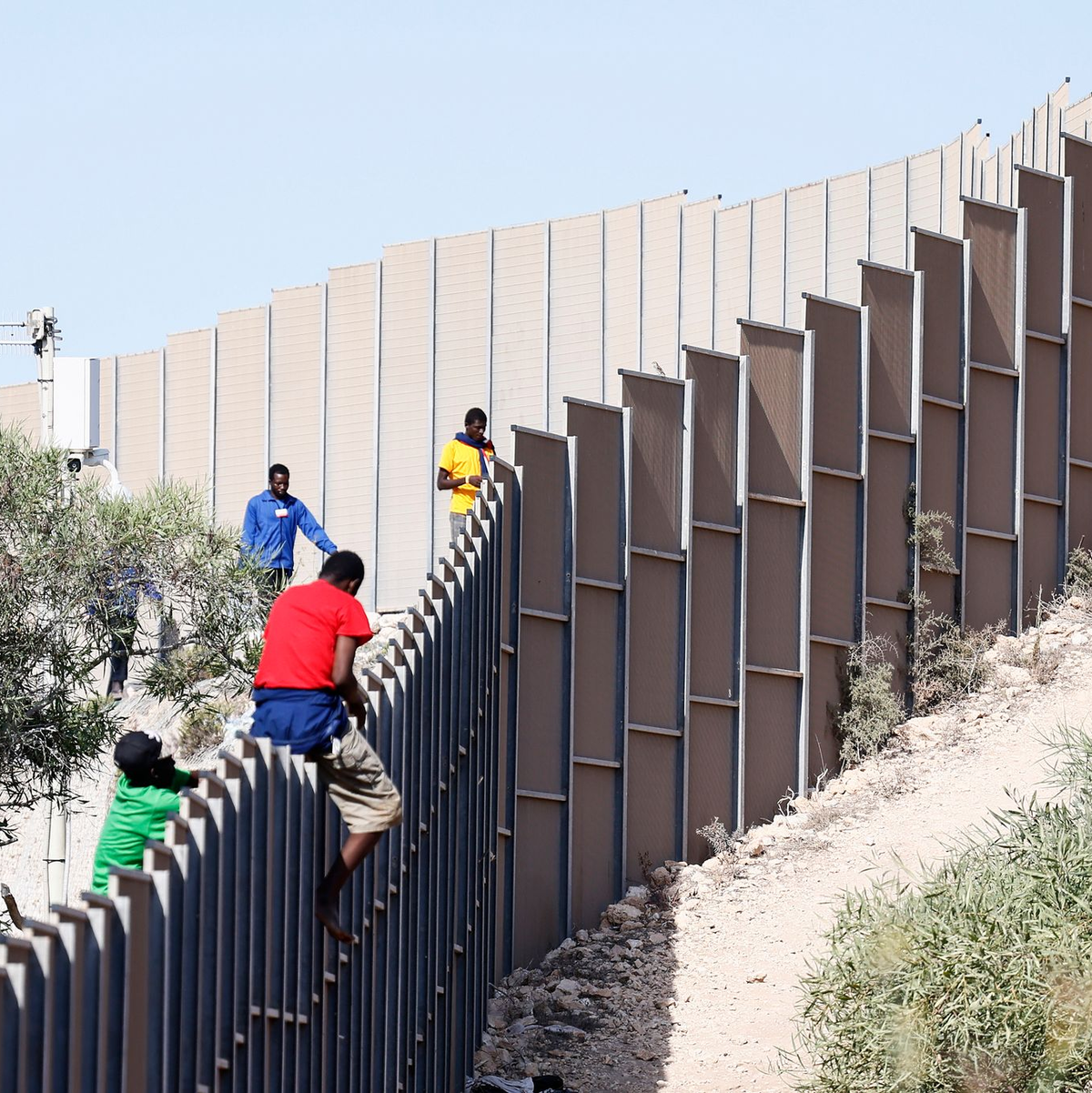 Migranten klettern über einen Zaun auf der Insel Lampedusa. - Foto: Cecilia Fabiano/LaPresse via ZUMA Press/dpa