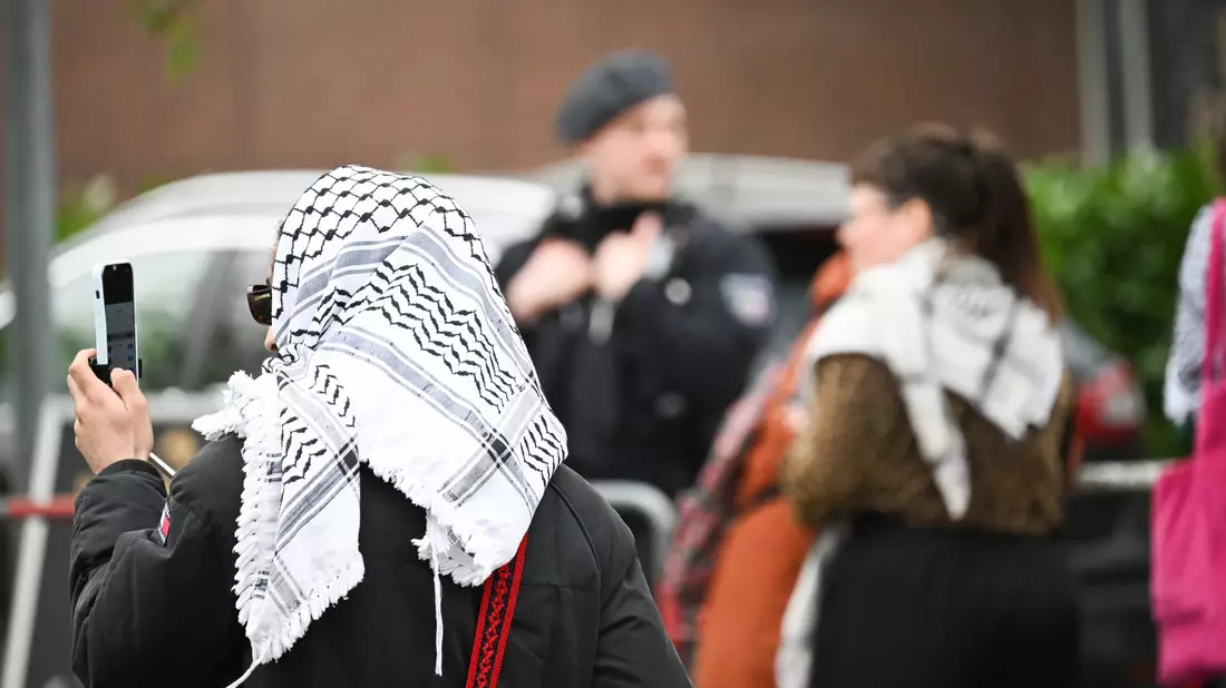 Teilnehmer des «Palästina-Kongresses» und Polizisten stehen vor der Veranstaltungshalle in Berlin-Tempelhof. - Bild: Sebastian Christoph Gollnow/dpa