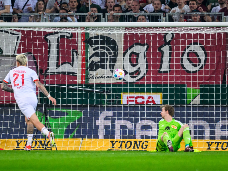Phillip Tietz (l) brachte Augsburg nach einem verunglückten Rückpass von Unions Diogo Leite in Führung. - Foto: Tom Weller/dpa