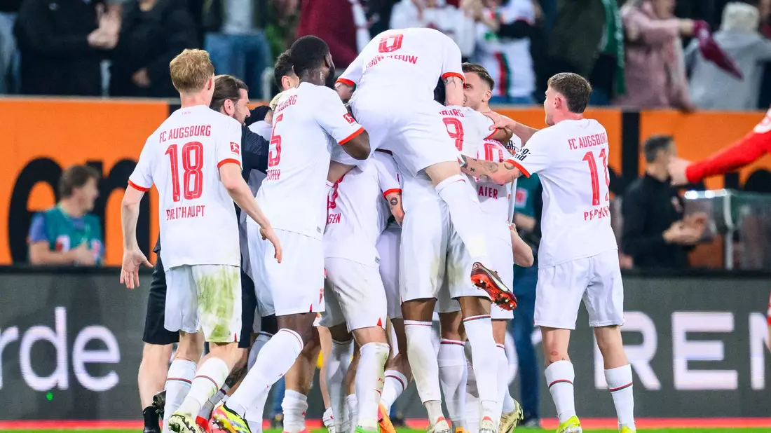 Die Augsburger Spieler feiern den Sieg gegen den 1. FC Union Berlin. - Bild: Tom Weller/dpa