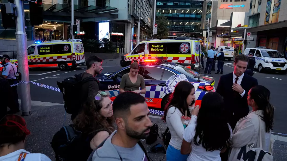 Eine Menschenmenge versammelt sich vor dem Westfield Shopping Centre. Medienberichten zufolge wurden in dem Einkaufszentrum in Sydney mehrere Menschen niedergestochen und eine Person von der Polizei erschossen. - Bild: Rick Rycroft/AP