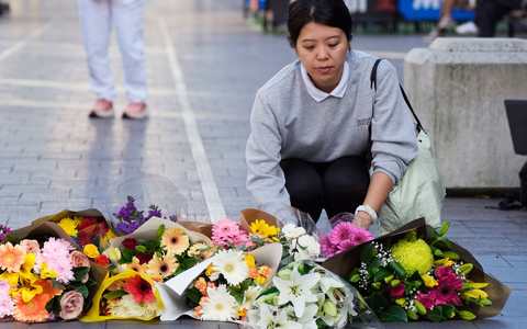 Eine Frau bringt Blumen zu einer improvisierten Gedenkstätte an der Bondi Junction. - Foto: Rick Rycroft/AP/dpa