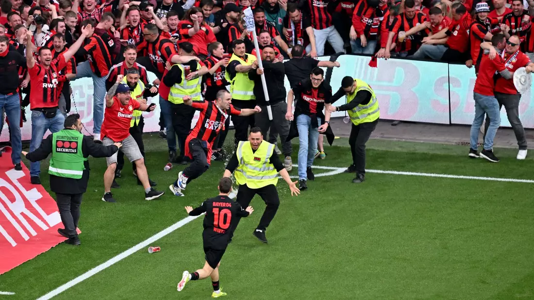 Schon nach dem viertem Leverkusener Tor stürmten Teile der Zuschauer den Platz. - Bild: David Inderlied/dpa