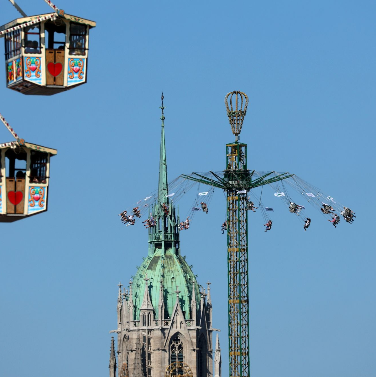 Blasmusiker gehen vor dem Riesenrad über den Festplatz. (Archivbild) - Foto: Karl-Josef Hildenbrand/dpa