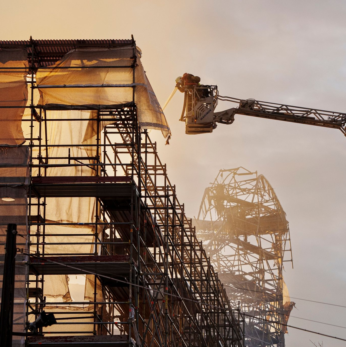 Feuerwehrleute setzen die Löscharbeiten an der alten Börse in Kopenhagen fort. - Foto: Liselotte Sabroe/Ritzau Scanpix Foto/AP