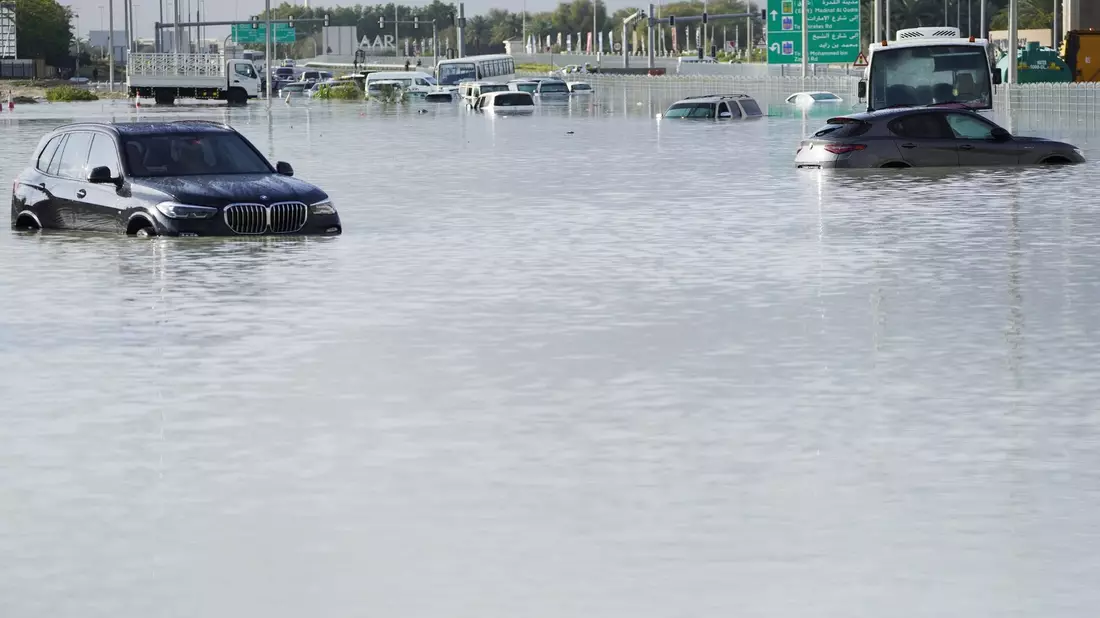 Fahrzeuge stehen verlassen im Hochwasser auf einer Hauptstraße in Dubai. - Bild: Jon Gambrell/AP/dpa