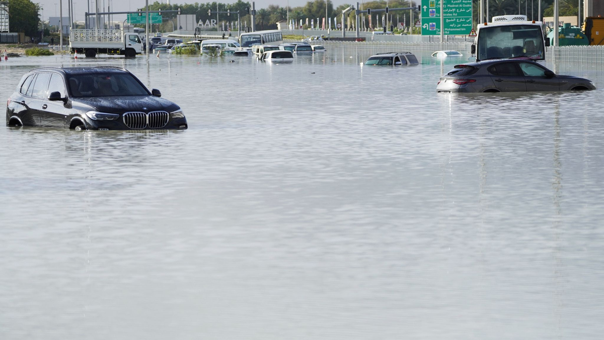 Fahrzeuge stehen verlassen im Hochwasser auf einer Hauptstraße in Dubai. - Foto: Jon Gambrell/AP/dpa
