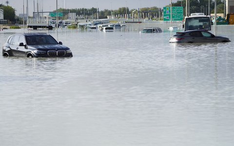 Fahrzeuge stehen verlassen im Hochwasser auf einer Hauptstraße in Dubai. - Foto: Jon Gambrell/AP/dpa