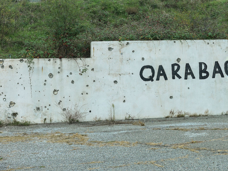 Spuren des Konflikts: Wand mit Einschusslöchern und dem Schriftzug Karabach. - Foto: Aziz Karimov/AP/dpa