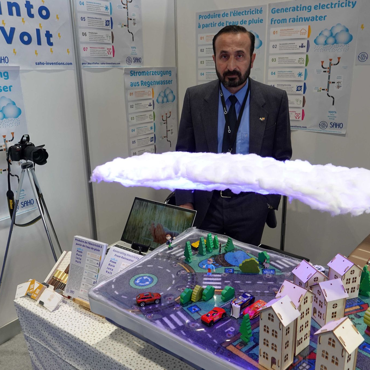 Khaled Al-Saho steht hinter seinem Modell, das die Produktion von Energie aus Regenwasser erklärt. - Foto: Christiane Oelrich/dpa