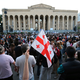 Demonstranten versammeln sich vor dem Parlamentsgebäude in Tiflis. - Foto: Zurab Tsertsvadze/AP/dpa