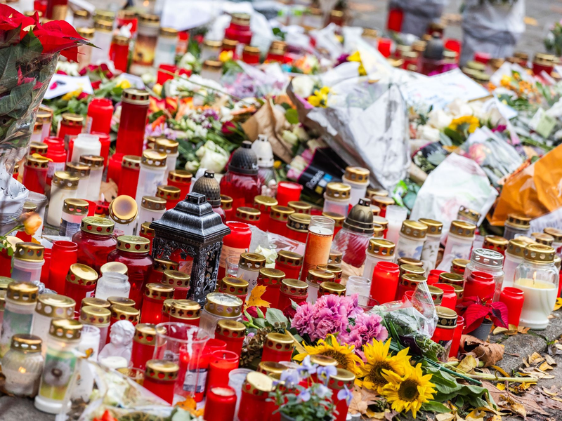 Kerzen und Blumen liegen vor dem Eingang der Waldbachschule. - Foto: Philipp von Ditfurth/dpa