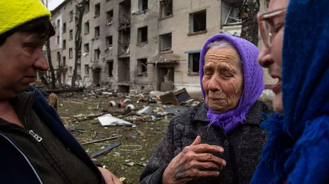 Frauen stehen in Lukiantsi in der Region Charkiw vor einem Haus, das durch einen russischen Luftangriff schwer beschädigt wurde. - Bild: Evgeniy Maloletka/AP/dpa