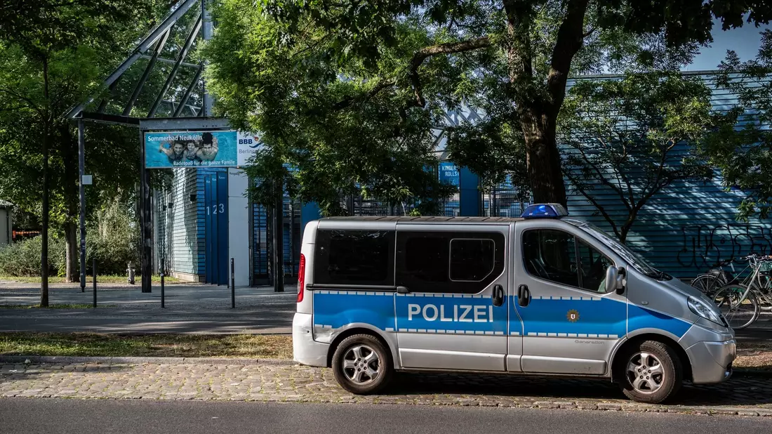 Sicherheitsmaßnahme: Ein Polizeifahrzeug steht im vergangenen Sommer vor einem Freibad in Berlin-Neukölln. - Bild: Paul Zinken/dpa