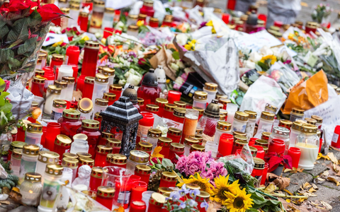 Kerzen und Blumen liegen vor dem Eingang der Waldbachschule. - Foto: Philipp von Ditfurth/dpa