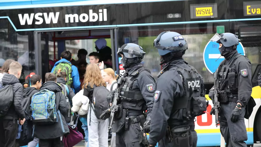 Polizisten führen Schüler in Wuppertal aus dem Gebäude in einen Evakuierungsbus. - Bild: Sascha Thelen/dpa
