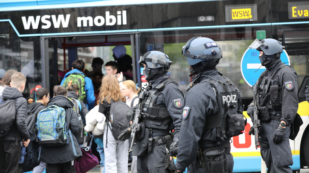 Polizisten führen Schüler in Wuppertal aus dem Gebäude in einen Evakuierungsbus. - Foto: Sascha Thelen/dpa