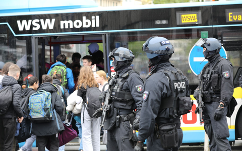 Polizisten führen Schüler in Wuppertal aus dem Gebäude in einen Evakuierungsbus. - Foto: Sascha Thelen/dpa Polizisten führen Schüler in Wuppertal aus dem Gebäude in einen Evakuierungsbus. - Foto: Sascha Thelen/dpa