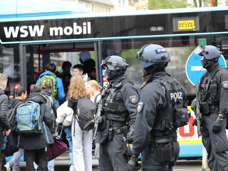 Polizisten führen Schüler in Wuppertal aus dem Gebäude in einen Evakuierungsbus. - Foto: Sascha Thelen/dpa